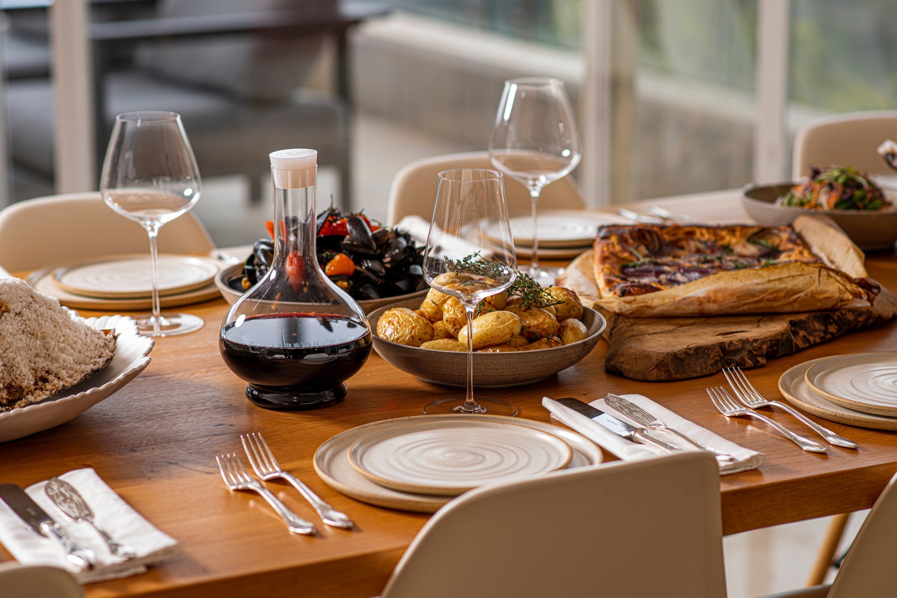 dinner table set with two grassl wine glasses and a grassl decanter filled with wine