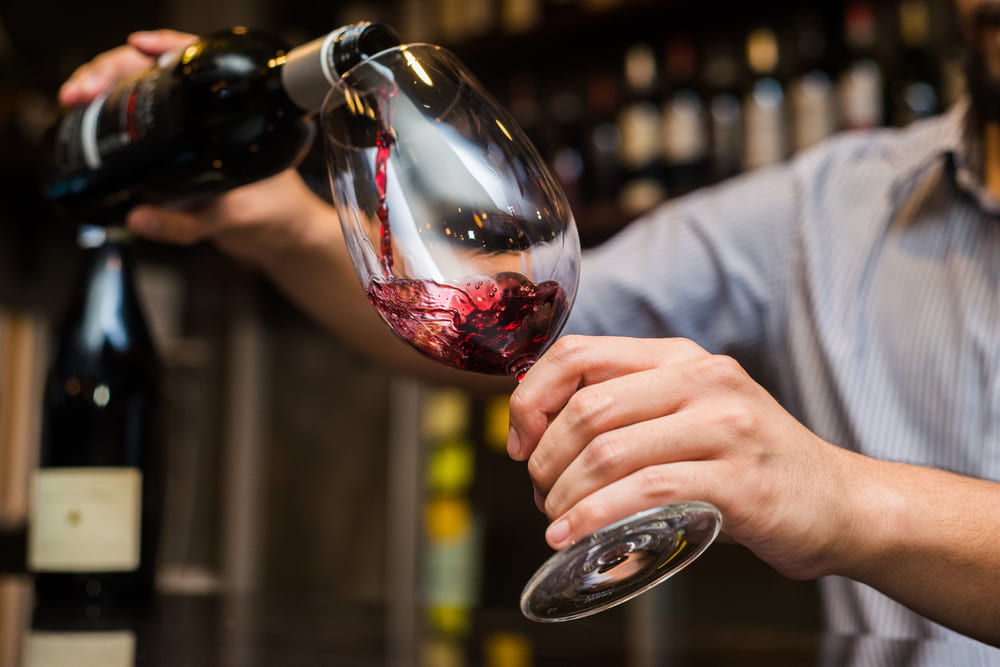 pouring red wine into a glass