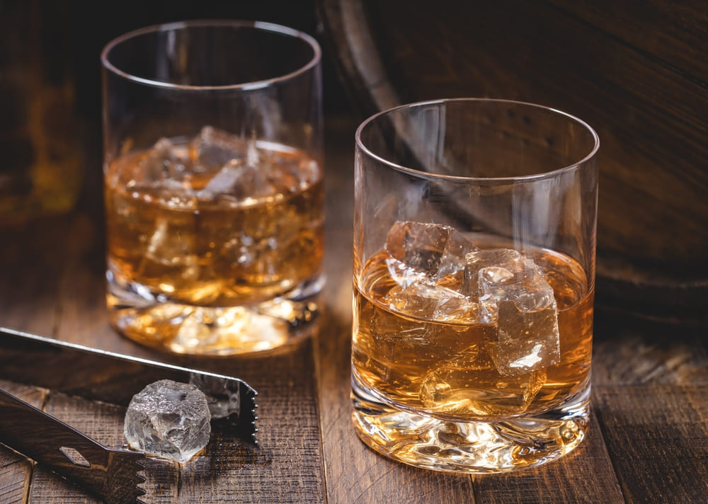 Two rocks glasses of whiskey with ice