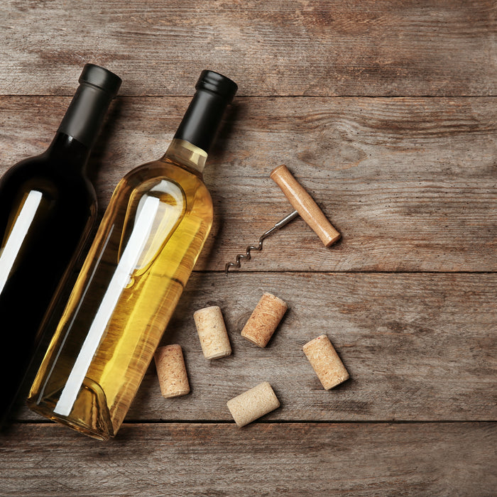 two wine bottles with wine stoppers and cork