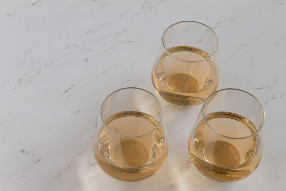 three stemless wine glasses with rose