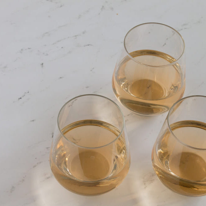 three stemless wine glasses with rose